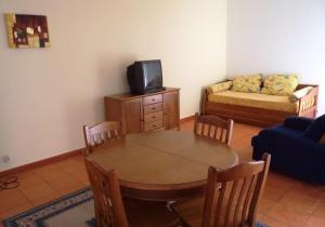 a living room with a table and a couch at HI Almograve – Pousada de Juventude in Almograve