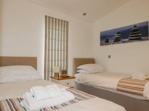 a hotel room with two beds and a window at 10 Horizon View in Liskeard