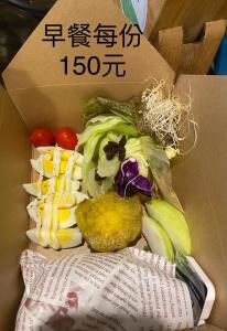 a box full of vegetables sitting next to a newspaper at Lohas Taitung B&B in Taitung City