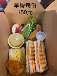 a box filled with a sandwich and bread and vegetables at Lohas Taitung B&B in Taitung City