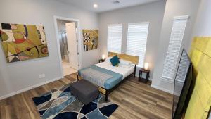 ヒューストンにあるSleeps 8 Excellent 3 Story Galleria Escape HPLEのベッドルーム1室(ベッド1台付)が備わります。壁には絵画が飾られています。
