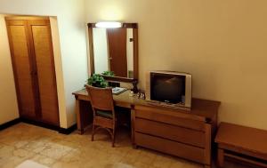a room with a desk with a television on it at Hotel Tugu Blitar in Blitar
