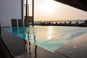 a swimming pool with the sunset in the background at Aqua Beautique Poolvilla in Jeju