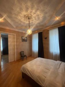 a bedroom with a bed and a chandelier at Natali Apartment in Tbilisi City +28 photos