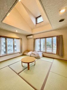 salon ze stołem i oknami w obiekcie 湯布院 ソナタ Yufuin Sonata w mieście Yufu
