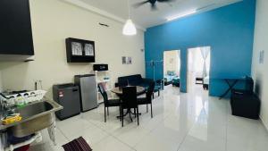 a kitchen with a table and chairs and a blue wall at VUE RESIDENCES Jln Pahang, KL city - 2 ROOM in Kuala Lumpur