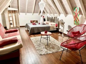 a living room with a bed and a couch and chairs at Papeth House in Le François