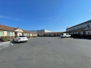 a parking lot with two cars parked in front of a building at Holiday Motel in Portland