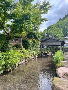 einen Fluss mit einem Pavillon neben einem Fluss in der Unterkunft 湯布院 ソナタ Yufuin Sonata in Yufu