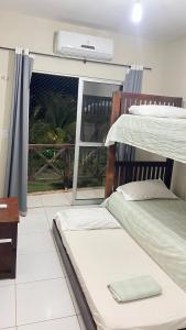 two bunk beds in a room with a window at Apartamento em Taiba-CE com vista para o mar in Taíba