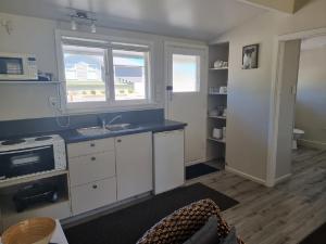 a kitchen with a sink and a stove and a window at Cheviot Motels, Cabins and Camp in Cheviot