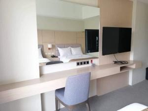 een slaapkamer met een bed, een tv en een stoel bij Sotogrande Neopolitan Hotel in Manilla