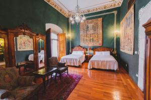 1 dormitorio con 2 camas, sofá y espejo en La Casa de la Marquesa, en Querétaro