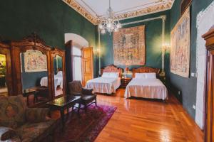 a bedroom with two beds and a couch and a mirror at La Casa de la Marquesa in Querétaro