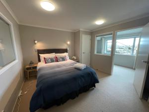 Un dormitorio con una cama grande y una ventana en Lakeside & Tennis Court Paradise, en Rotorua