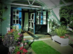una casa con una puerta azul y algunas plantas en Hotel zum alten Torfkahn en Osterholz-Scharmbeck