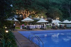 a group of people sitting under umbrellas next to a pool at SV Boutique Resort in Vung Tau
