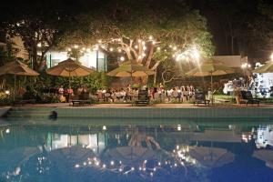 a group of people sitting under umbrellas by a pool at night at SV Boutique Resort in Vung Tau +39 photos