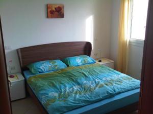 a bed with a wooden headboard and blue sheets at Traumblick in Valledoria