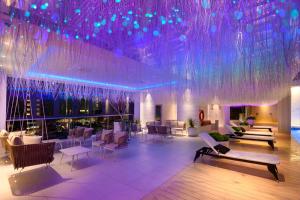 a lobby with purple lighting and chairs and tables at The Granite Luxury Hotel Penang in George Town