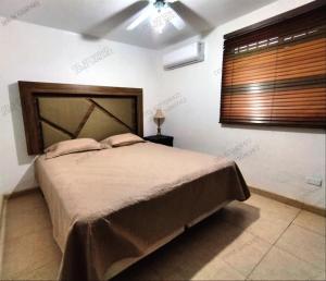 une chambre avec un grand lit et une fenêtre dans l'établissement Condominio 231 Loma Bonita, enfrente de la alberca!, à San Carlos 8 autres photos