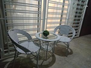 three chairs and a table in front of a window at Ana Homestay D'Airport in Melaka