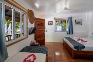 a bedroom with two beds and a window at Evolution Dive and Beach Resort in Malapascua Island