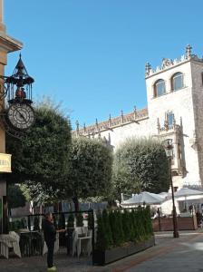 Un uomo in piedi di fronte a un palazzo con un orologio di Cordón 4 a Burgos