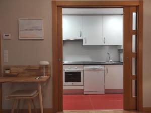 a kitchen with white cabinets and a red floor at Cordón 4 in Burgos