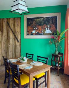 Hotel Santo Vanuatu في لوجنفيل: غرفة طعام مع طاولة و لوحة على الحائط