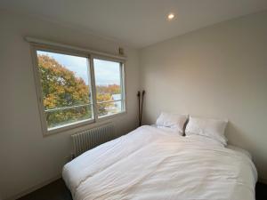 a white bed in a room with a window at Sakura Apartments in Kutchan