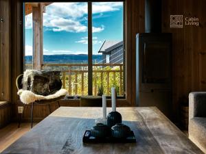 a dining room table with a view of a mountain at Brand new cottage with super views Skeikampen in Svingvoll