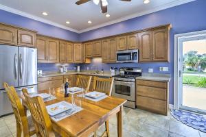 a kitchen with wooden cabinets and a wooden table at The Shell House with Pool and Golf Access! in Titusville
