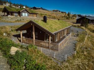 a house with a grass roof on a hill at Brand new cottage with super views Skeikampen in Svingvoll