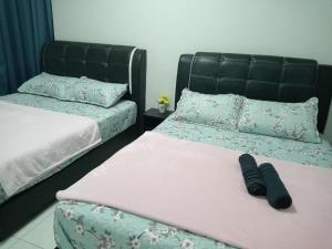 two beds sitting next to each other in a bedroom at Ana Homestay D'Airport in Melaka