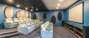 a conference room with white chairs and a screen at The blyde Royal platinum bnb in Pretoria