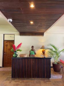 a man standing behind a counter in a room at Hotel Santo Vanuatu in Luganville