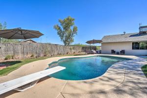 a swimming pool in the backyard of a house at Sunny Phoenix Home with Pool and Backyard Oasis! in Phoenix