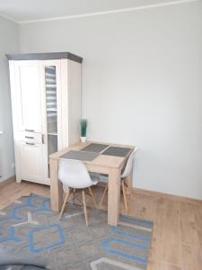 a table and a white chair in a room at APARTAMENTY CENTRUM Lipowa 16 in Białystok