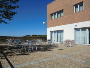 a group of tables and chairs in front of a building at HI Foz Coa - Pousada de Juventude in Vila Nova de Foz Coa +20 photos
