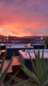 ein Sonnenuntergang über einem Gebäude mit einer Anlage im Vordergrund in der Unterkunft B&B Sweet Sleep in Neapel
