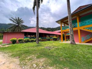 a building with palm trees in front of it at papaya resort in Kampung Tekek