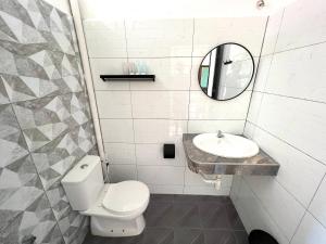a white bathroom with a toilet and a sink at papaya resort in Kampung Tekek