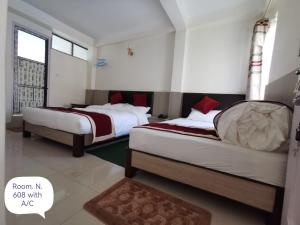 מיטה או מיטות בחדר ב-Om Bramha Hotel