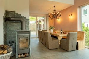 uma sala de jantar com lareira, mesa e cadeiras em Spacious Home Sauna Hot Tub Pool Patio BBQ em Hohenfels-Essingen