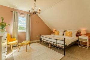 una camera da letto con un letto, una sedia e una finestra di Spacious Home Sauna Hot Tub Pool Patio BBQ a Hohenfels-Essingen Altre 17 foto