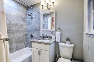 Un baño con inodoro, lavabo y bañera. en 4 Mi to ATandT Stadium Modern Home with Fenced Yard, en Arlington 23 fotos más
