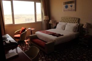 a hotel room with a large bed and a window at Al Salam Grand Hotel in Al Buraymī