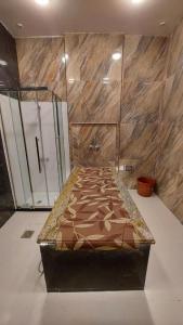 Al Salam Grand Hotel في البريمي: سرير في غرفة مع دش وحوض استحمام
