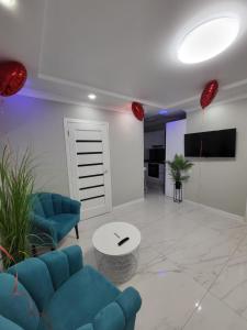a living room with a blue couch and a table at Escapada romantica cu jacuzzi in Chisinau in Chişinău